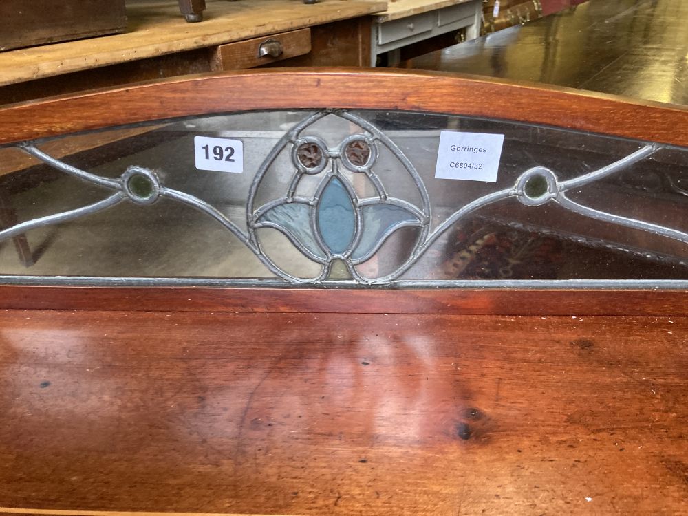 An Edwardian inlaid mahogany side table, the superstructure with an inset stained glass panel, width 95cm, depth 50cm, height 91cm